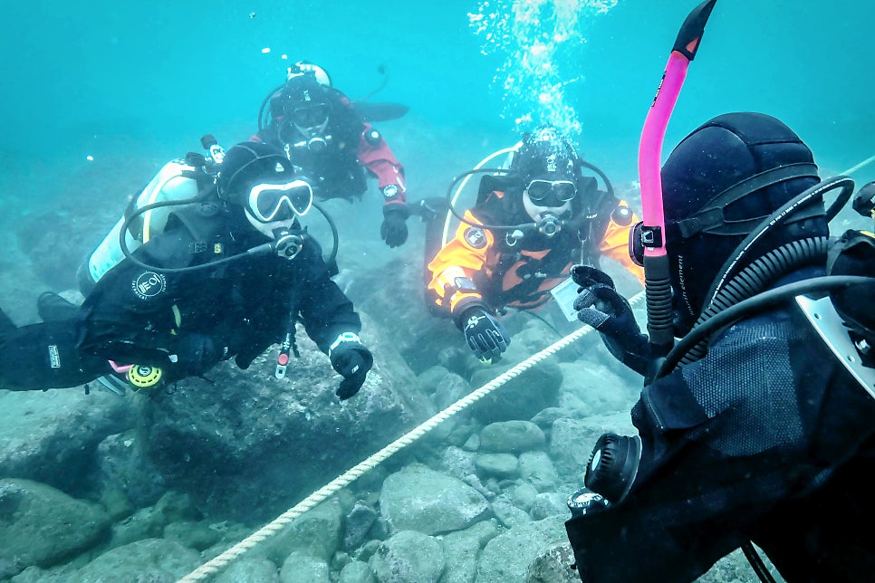 Scuba divers exploring a reef line underwater in Korea with NB Divers