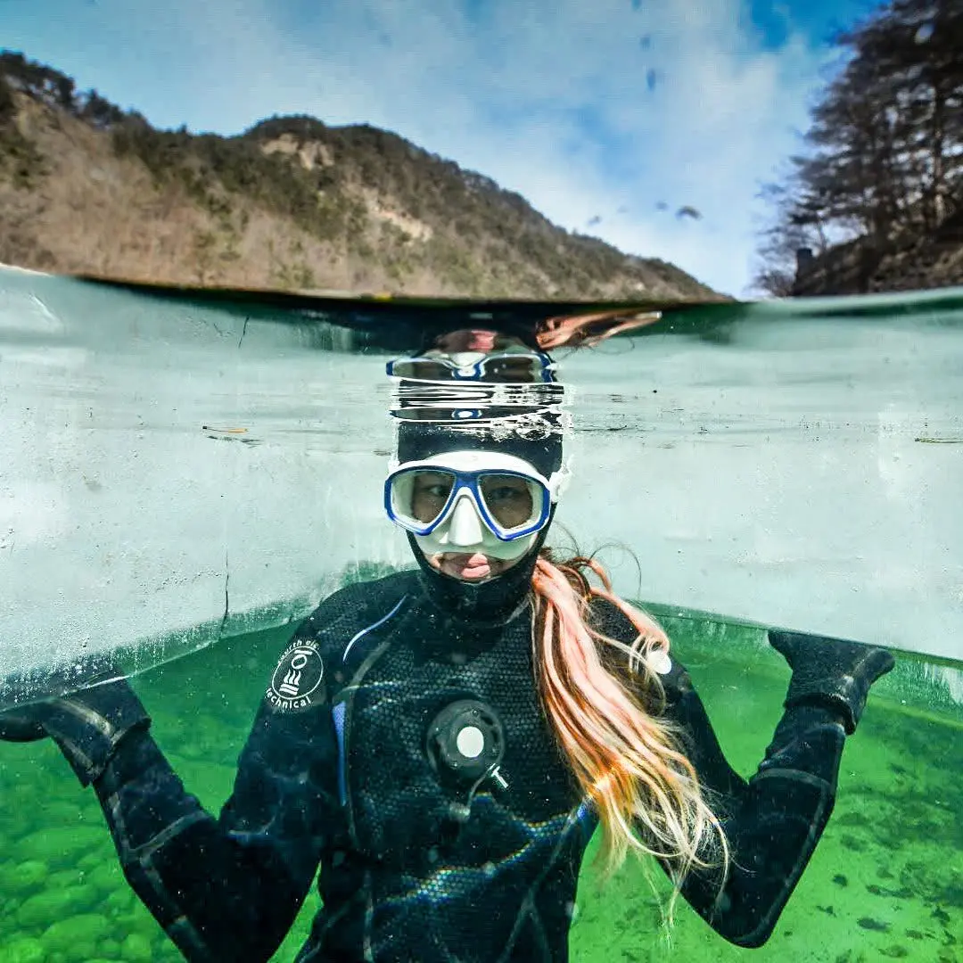 Ice diver looking up from under the ice, Baekdam Valley