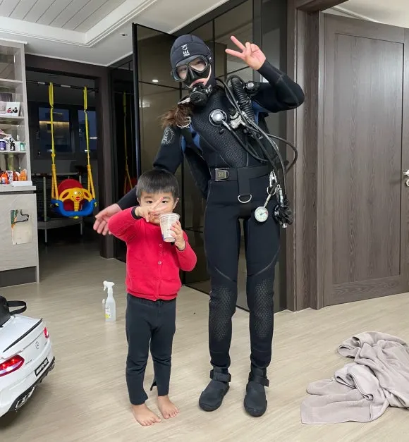 거실에서 스쿠버 장비를 착용한 김유리 다이브마스터와 아이
