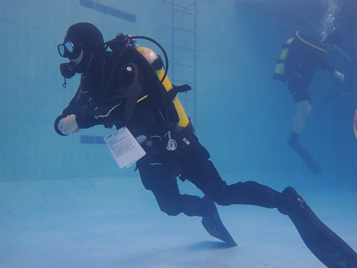 Solo scuba diver hovering in neutral buoyancy in open water, working on confidence and control