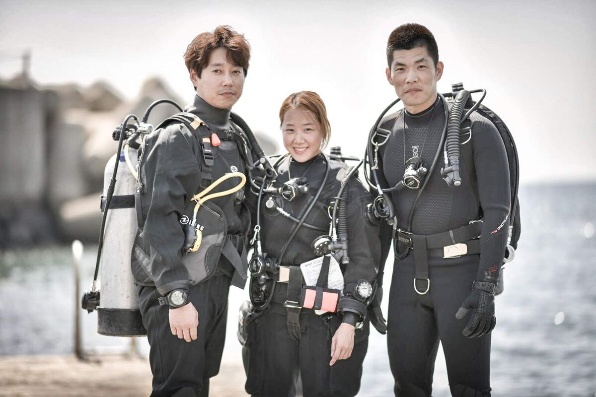 다이브마스터 과정을 마친 다이버들이 동해 방파제 앞에서 장비를 착용하고 서 있는 모습